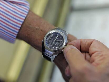 Un hombre mueve la manecilla del reloj para cambiar la hora, en Madrid.