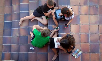 Niños jugando con aparatos electrónicos.