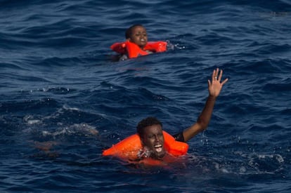 Dos náufragos subsaharianos piden auxilio tras zozobrar su embarcación cerca de la costa de Libia. / C. MCGRATH (GETTY IMAGES)