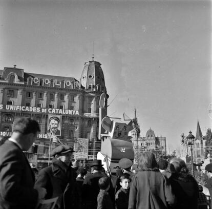 Un grupo de transeúntes acompañan a un muñeco que caricaturiza a Franco, en 1937 en la Plaza de Catalunya de Barcelona.