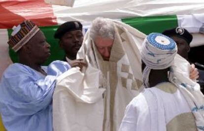 Miembros de la comunidad fulani nigeriana visten ayer con ropas tradicionales al ex presidente estadounidense Bill Clinton.