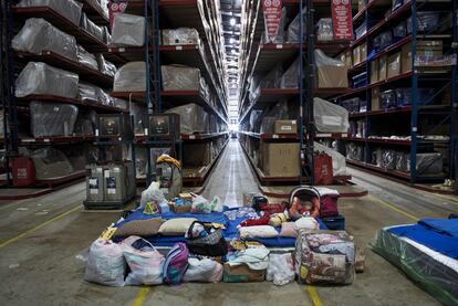 Un bebe duerme en su cuna junto a las pertenencias de su familia en la tienda Gallery Furniture.