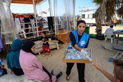 Una trabajadora humanitaria reparte desinfectante a personas desplazadas de Dahiye, un suburbio sureño de la capital libanesa Beirut, el 12 de octubre de 2023.