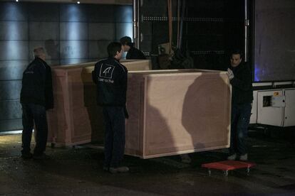 Varios operarios descargan el camión preparado para el traslado de las piezas de arte de Sijena.