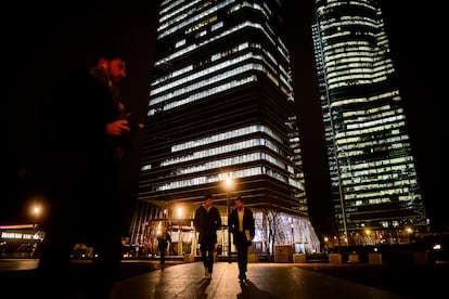 Varias personas en horario de salida del trabajo en la zona de las cuatro torres de la Castellana, en Madrid.