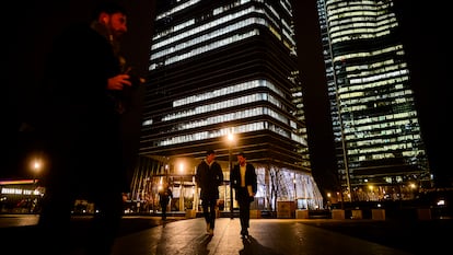 Varias personas en horario de salida del trabajo en la zona de las cuatro torres de la Castellana, en Madrid.