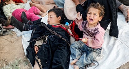 Una familia de refugiados sirios espera entre la frontera de Siria y Turquía.