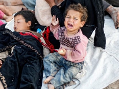 Una familia de refugiados sirios espera entre la frontera de Siria y Turquía.