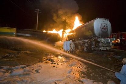Bomberos paquistaníes luchan por apagar los incendios de la veintena de camiones de la OTAN asaltados en Islamabad.
