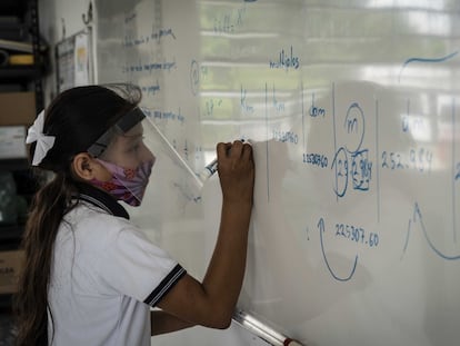 Una alumna escribe en el pizarrón durante el regreso presencial a las escuelas, tras más de un año de cierre por la pandemia de covid 19, en noviembre de 2022.