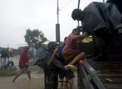 Varios militares durante la evacuación una mujer en Puerto San Carlos.