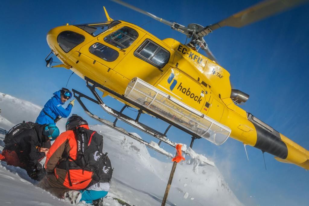 El helicóptero acaba de dejar a los esquiadores en la montaña e inicia el despegue. La operación de depósito de los esquiadores apenas dura un minuto.