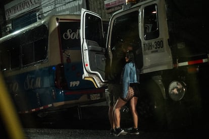 Una joven se acerca a los camiones a ofrecer sus servicios.