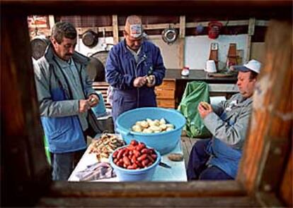 Trabajadores de Sintel pelan patatas para la comida en el campamento de la Castellana de Madrid.
