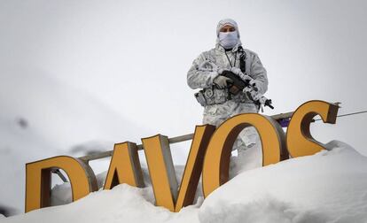 Un policía camuflado monta guardia en el tecto de un hotel en Davos.