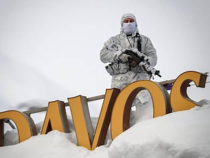 Un policía camuflado monta guardia en el tecto de un hotel en Davos.
 