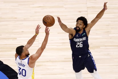 Stephen Curry, de Golden State Warriors, lanza a canasta con la oposición de Spencer Dinwiddie, de Dallas, en el partido de este domingo.