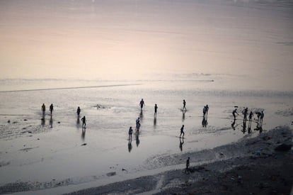 Trabajadores indios cruzan el río Ganges tras terminar la jornada laboral para la construcción de un puente flotante de cara al próximo festival Kumb Mela, en Allahabad. 