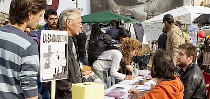 Grupo de personas firmando esta mañana en la plaza Cataluña de Barcelona