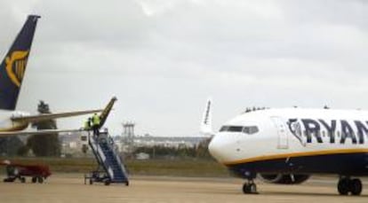 Dos operarios de la compañía Ryanair reparan los daños producidos en el ala derecha de un avión que se vio implicado anoche en un accidente en el aeropuerto de San Pablo de Sevilla. EFE/Archivo