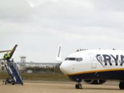 Dos operarios de la compañía Ryanair reparan los daños producidos en el ala derecha de un avión que se vio implicado anoche en un accidente en el aeropuerto de San Pablo de Sevilla. EFE/Archivo