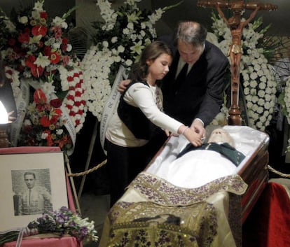 Familiares del torero introducen un sobre en la chaqueta en la capilla ardiente instalada en la sala Alcalá de la plaza de toros de Las Ventas y en la que se han colocado fotos que retratan la vida profesional del diestro.