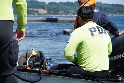 Agentes de la Policía de Investigación analizan la zona donde cayó la aeronave que piloteaba Piñera, en el lago Ranco, el miércoles.