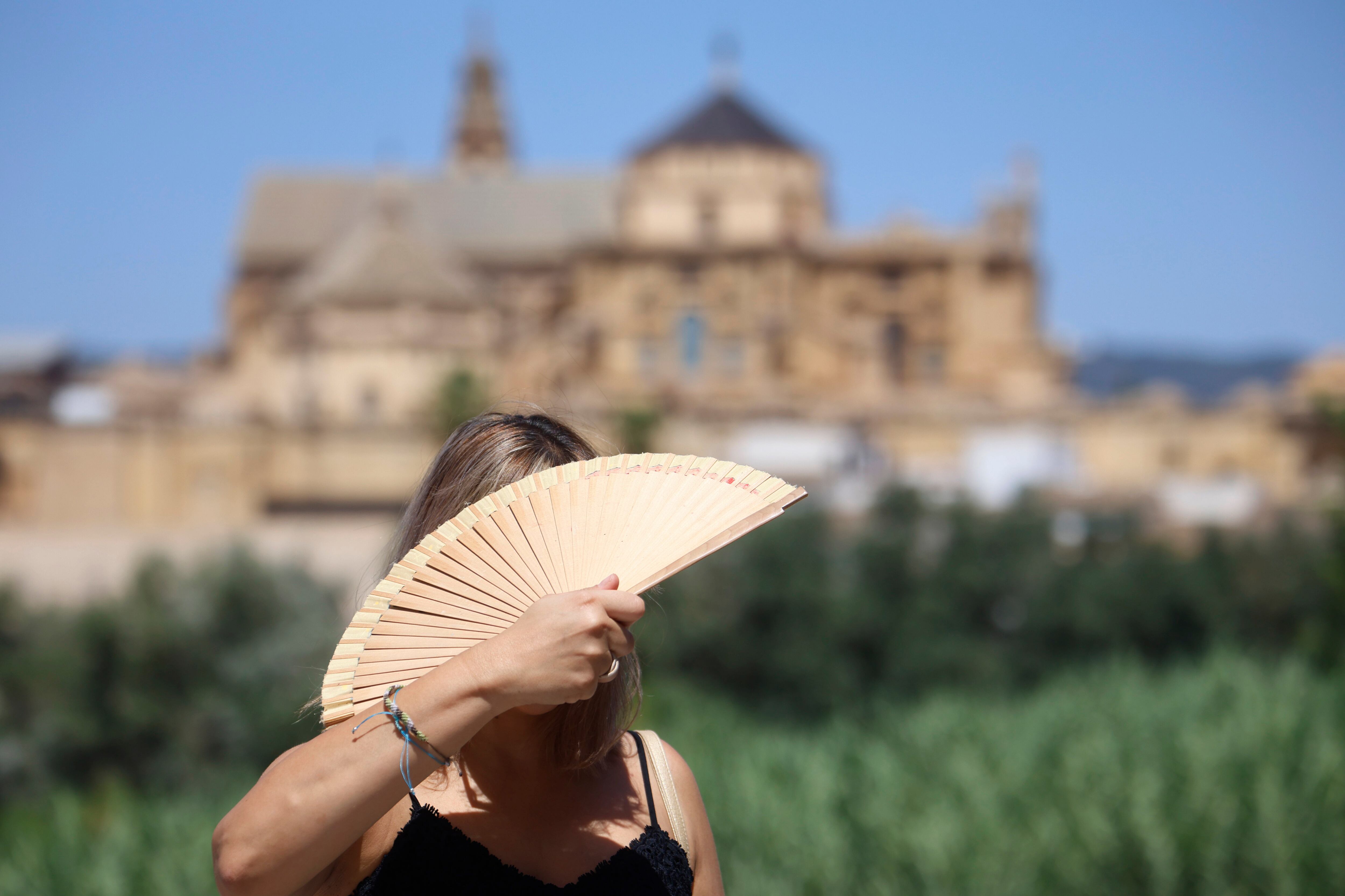 Una turista se abanica en el puente romano de Córdoba, en agosto. 