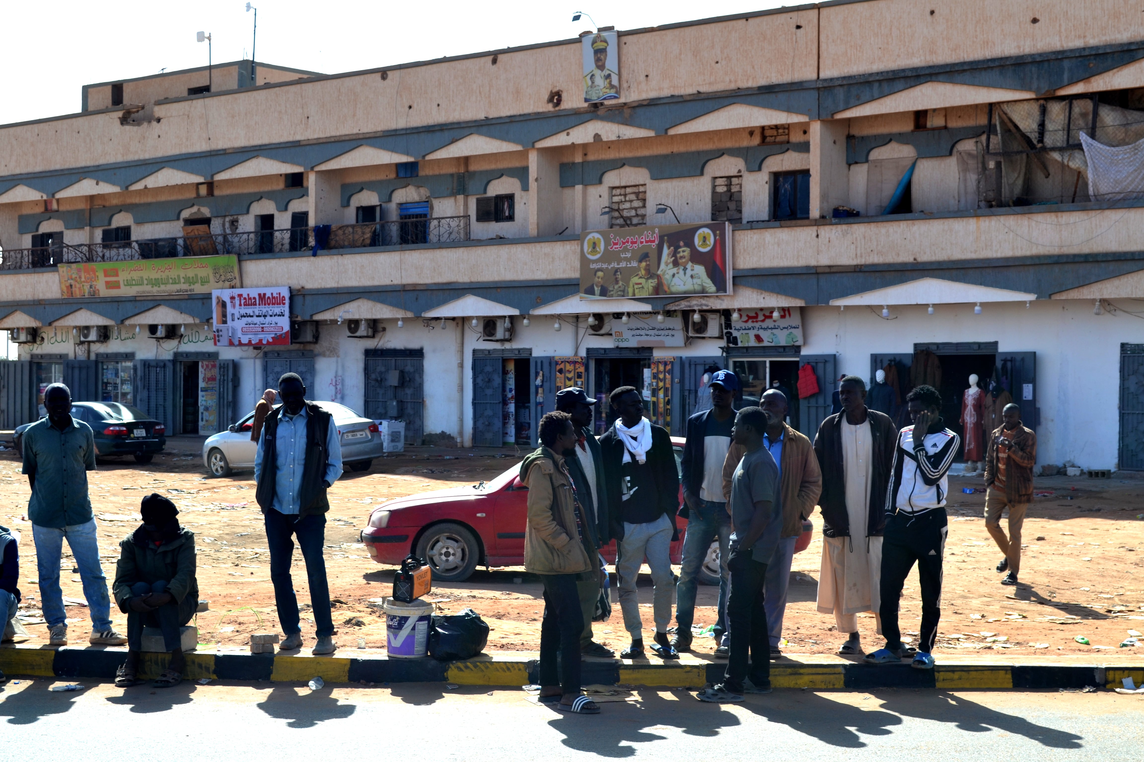 Refugiados sudaneses buscan trabajo al borde de una carretera en Kufra.