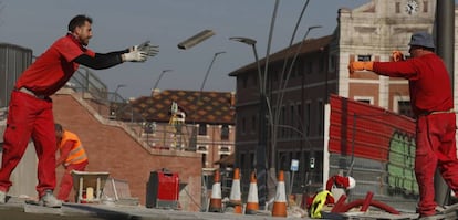 Trabajadores de la construcción urbanizan una calle en Bilbao.