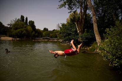 Un joven salta al río Arga, a su paso por Pamplona (Pamplona), durante la ola de calor el 9 de agosto.