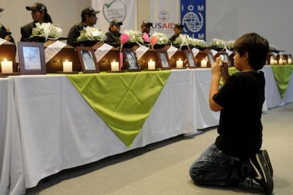 El niño colombiano Juan Andrés Córdoba hace una fotografía de los restos de su padre, durante la ceremonia de entrega de los cadáveres de 17 personas desaparecidas desde hace más de diez años a sus familiares, el martes en Medellín.