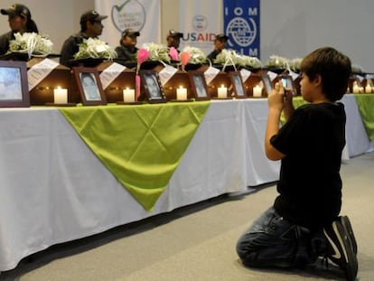 El ni&ntilde;o colombiano Juan Andr&eacute;s C&oacute;rdoba hace una fotograf&iacute;a de los restos de su padre, durante la ceremonia de entrega de los cad&aacute;veres de 17 personas desaparecidas desde hace m&aacute;s de diez a&ntilde;os a sus familiares, el martes en Medell&iacute;n.  