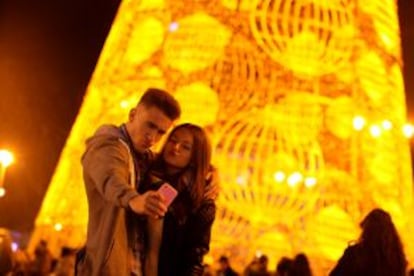 Una pareja se fotografía frente al árbol navideño de la Calle Montera.