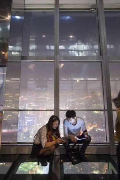 Dos visitantes en el mirador más elevado del rascacielos Shanghai World Financial Center, en el piso 100ª, a 474 metros de altura.