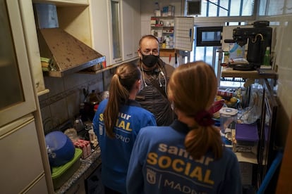 El padre conversa en la cocina con dos trabajadoras del Samur Social, institución municipal que acogerá temporalmente a esta familia en un recurso de emergencia.