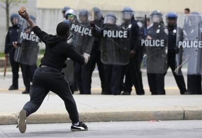 Un hombre lanza un ladrillo a la policía tras el funeral de Freddie Gray en Baltimore. Gris murió a causa de lesiones de la columna alrededor de una semana después de que fue arrestado y transportado en una camioneta Departamento de Policía. 