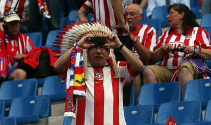 Un seguidor del Atlético de Madrid fotografía el estadio con un tocado de plumas.