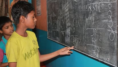 Los niños del Drop In center en Surat en clase de matemáticas repasan sus ejercicios.