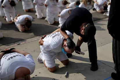 Manifestantes participan en un performance que simboliza la detención de personas enviadas al Centro de Confinamiento del Terrorismo (CECOT) de El Salvador, afuera del Edificio Federal Edward R. Roybal en Los Ángeles, California, el 17 de julio de 2025. 