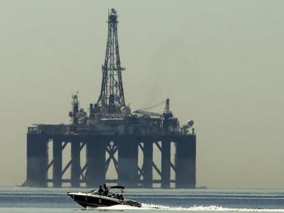 Una lancha pasa frente a una plataforma petrolífera. EFE/Archivo