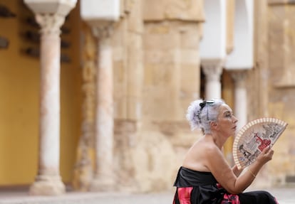 Una mujer se abanica en el Patio de los Naranjos de Córdoba.