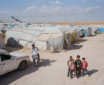 Un grupo de niños mira a cámara en un campo de desplazados, en la provincia de Alepo, en el norte de Siria, el 30 de septiembre de 2021. La Administración Autónoma del Este y Norte de Siria (AANES) quería que los desplazados abandonaran las escuelas para permitir que otros niños siguieran con su educación, pero los campamentos cercanos que albergan a miles de refugiados internos no pueden acoger a más.