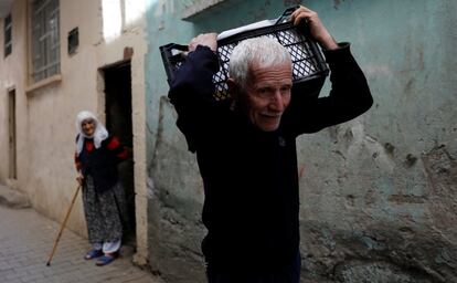 Un hombre porta sus pertenencias a través de un estrecho callejón, en Diyarbakir (Turquía).