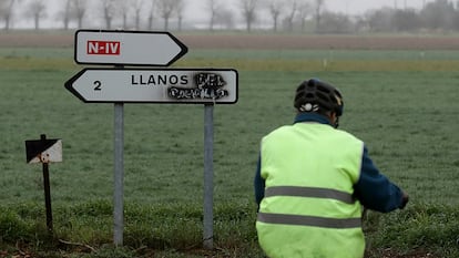 Un ciclista, frente al cartel del camino hacia Llanos del Caudillo.