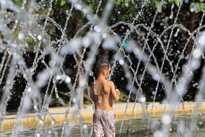 Un niño juega con los chorros de agua para refrescarse en el parque "Madrid Río". 