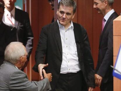 Los ministros de Finanzas griego y alem&aacute;n se saludan en el Eurogrupo.