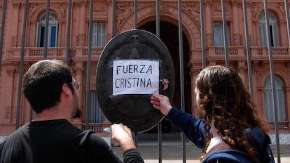 Dos hombres dejan una flor en la Casa Rosada, en Buenos Aires.