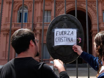 Dos hombres dejan una flor en la Casa Rosada, en Buenos Aires.