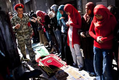 Unas mujeres rezan en la plaza de la Liberación.